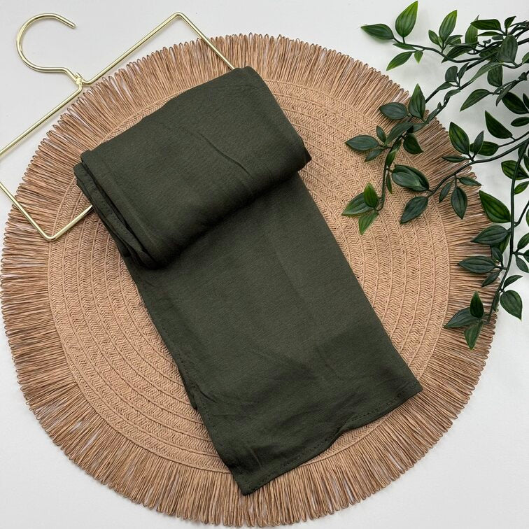 Jersey Hijab in Dark Olive Green, soft and breathable with a thick, flexible design, providing secure coverage and easy styling for active, everyday wear.